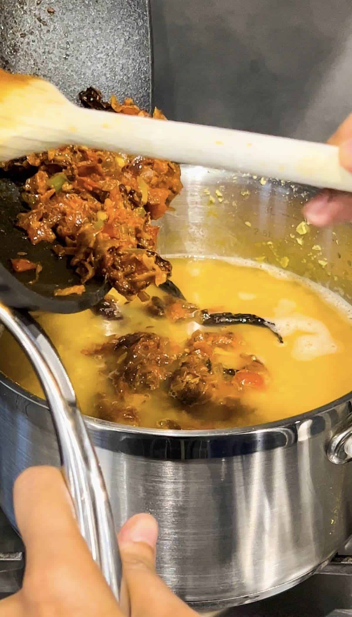 Transfer the tadka to the pot with cooked lentils